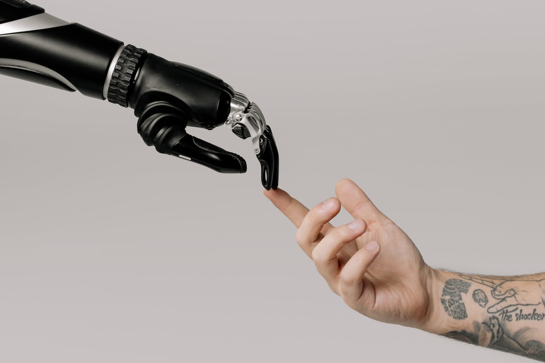 Éticas para Inteligencias Artificiales bionic hand and human hand finger pointing